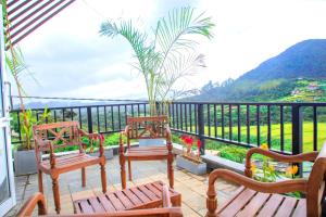 uma varanda com bancos e vista para uma montanha em Aquaa Leaf Residences em Nuwara Eliya