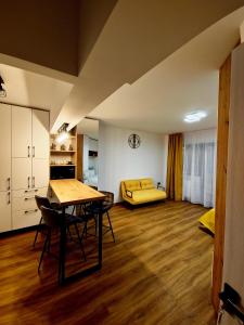 uma sala de estar com uma mesa e um sofá amarelo em Central Nest Apartment em Brasov