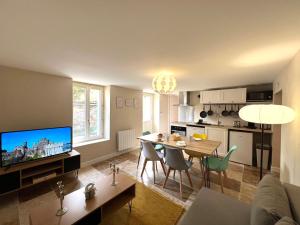 a living room with a table and a kitchen at Le Troglodyte - Home Homy in Montluçon