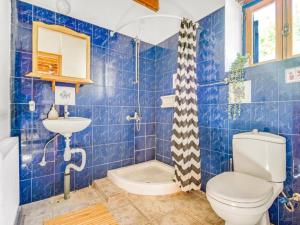 La salle de bains est pourvue de carrelage bleu, de toilettes et d'un lavabo. dans l'établissement Cornaro House, à Arsos