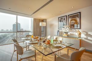 a dining room with a glass table and chairs at Golden Sands Boutique Hotel-Dubai Creek in Dubai