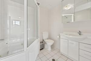La salle de bains blanche est pourvue de toilettes et d'un lavabo. dans l'établissement Spacious Ensuite Room in a City Centre Duplex Apartment-2, à Canberra