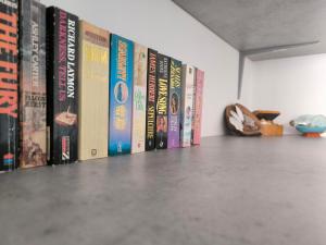 a row of books lined up on a shelf at Sunorama Beach Garden - Seaview in Larnaca