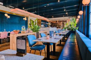 een restaurant met tafels en stoelen en een bar bij Hotel Corps de Garde in Groningen