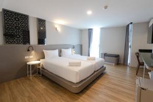 ein Schlafzimmer mit einem großen weißen Bett in einem Zimmer in der Unterkunft วัน บัดเจท ตาก แม่สอด - One budget hotel Tak Maesot in Mae Sot