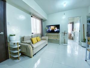 碧瑶QFandZ Baguio Homestay at BRENTHILL Condominium的带沙发和电视的客厅