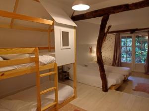 a bedroom with two bunk beds and a window at La chaumière de jacquotte linge de lits en option in Limpiville