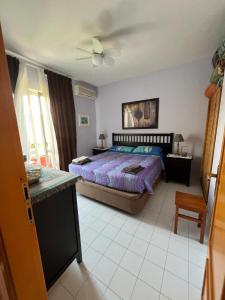 Schlafzimmer mit einem Bett und einem Deckenventilator in der Unterkunft Casa al mare con giardino vicino a Roma in Torvaianica