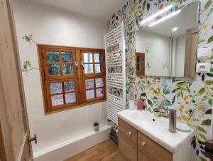 a bathroom with a sink and a mirror and a tub at La chaumière de jacquotte linge de lits en option in Limpiville +10 photos
