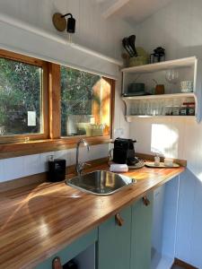 una cucina con lavandino e piano di lavoro in legno di Mágica Tiny House con vista a la Montaña a San Martín de los Andes