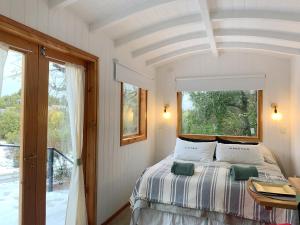 uma cama num quarto com uma janela e uma cama sidx sidx em Mágica Tiny House con vista a la Montaña em San Martín de los Andes