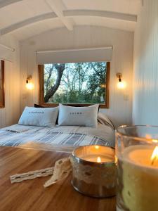 1 dormitorio con 1 cama y velas sobre una mesa en Mágica Tiny House con vista a la Montaña en San Martín de los Andes