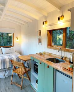 eine Küche mit einem Waschbecken und ein Bett in einem Zimmer in der Unterkunft Mágica Tiny House con vista a la Montaña in San Martín de los Andes