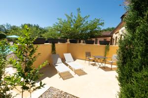 a patio with chairs and a table on a fence at Le Clos du Peintre in Sarlat-la-Canéda