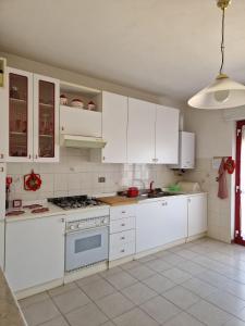 uma cozinha com electrodomésticos brancos e armários brancos em Appartamenti Lido Riccio em Ortona