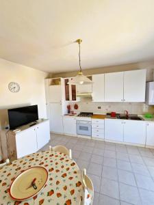 uma cozinha com armários brancos e uma mesa com um prato em Appartamenti Lido Riccio em Ortona