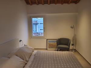 a bedroom with a bed and a chair and a window at Casa Ballardini Via Baracca 66 in Lugo