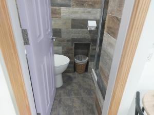 a bathroom with a toilet and a tiled floor at Ellerhow in Windermere