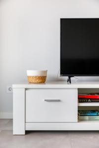 a white cabinet with a television on top of it at Kasino II 3ºI in Monte Gordo