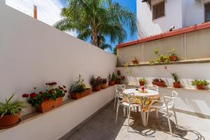 een patio met een tafel en stoelen en potplanten bij Guest House Eleonora by BarbarHouse in Alliste