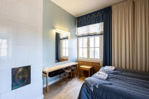 a bedroom with a bed and a desk and a table at Juhlatalo Johtola in Rauma