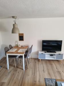 a dining room with a table and a tv at idylische Ferienwohnung in Schollbrunn
