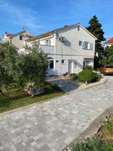 a large white house with a driveway at Apartment Lucia in Punat