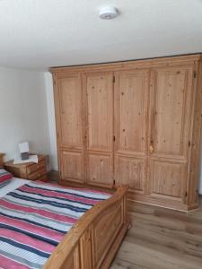 1 dormitorio con armarios de madera y 1 cama en idylische Ferienwohnung, en Schollbrunn