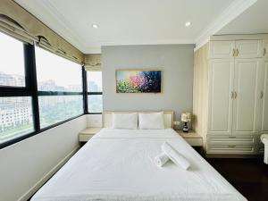 um quarto com uma grande cama branca e janelas em HKG-Căn hộ Cầu Giấy em Hanói