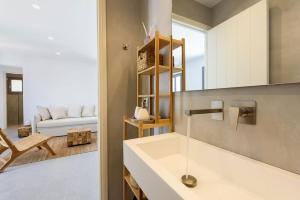 a bathroom with a sink and a living room at OneAlyki in Aliki +38 photos