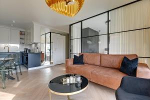 un soggiorno con divano e tavolo di Rezydencja Wintera by Downtown Apartments a Danzica