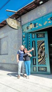 a man and a woman standing in front of a building at "Sofia" Guest House in Samarkand
