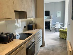 a kitchen with a counter and a living room at Linden Garden apartment in Bedford