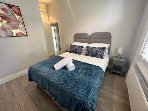 a bedroom with a large bed with two pillows at Linden Garden apartment in Bedford