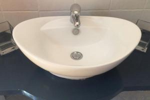 ein weißes Waschbecken mit einem Wasserhahn in einem Badezimmer in der Unterkunft Kos Guest House with patio and garden in Antimácheia