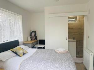 a bedroom with a large bed and a bathroom at Corby Guest House in Corby