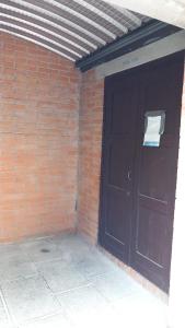 a black garage door in a brick wall at B&B La Fortezza in Comacchio