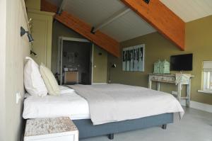 a bedroom with a large bed in a room at Erve 't Hacht in Ane