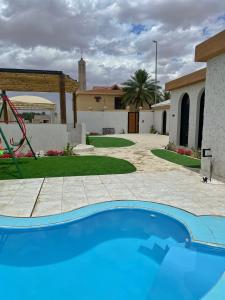 - une piscine dans une cour avec une maison dans l'établissement unique chalet, à Unayzah
