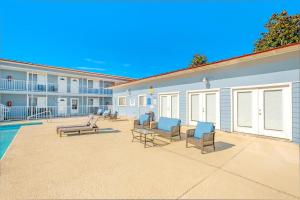 a patio with chairs and a pool in front of a building at Oak Shores 130 in Biloxi