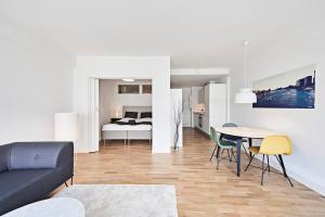 a living room with a couch and a table and a bed at Cool 1-bedroom apartment with a private terrace - 23 in Copenhagen