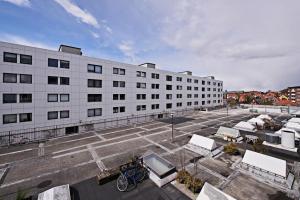 an empty parking lot in front of a large building at Cool 1-bedroom apartment with a private terrace - 23 in Copenhagen +3 photos