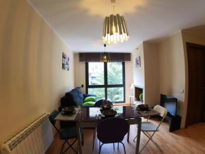 a living room with a table and chairs and a couch at Soldeu Paradis La Solana in El Tarter