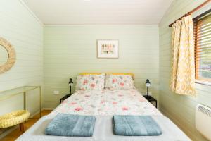1 dormitorio con cama y ventana en Iris Lodge, with cosy Log Burner 