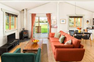 a living room with a couch and a table at Iris Lodge, with cosy Log Burner 