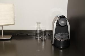 um aparelho preto sentado numa secretária com dois copos em Concept Hotel Landhaus em Burgdorf