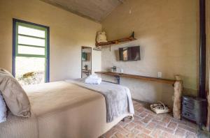 a bedroom with a large bed and a window at Cafezal em Flor Turismo e Cafés Especiais in Monte Alegre do Sul