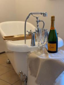 a bottle of wine and glasses on a table next to a bath tub at Oase am Pferdemarkt - exklusives Wohnen im Herzen Ostfrieslands - Luxus und Wohlfühlatmosphäre in Aurich +10 photos