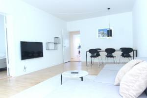 Wonderful 2-bed in Frederiksberg C في كوبنهاغن: غرفة معيشة بيضاء مع أريكة بيضاء وطاولة