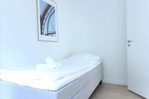 Wonderful 2-bed in Frederiksberg C في كوبنهاغن: سرير عليه شراشف بيضاء في الغرفة